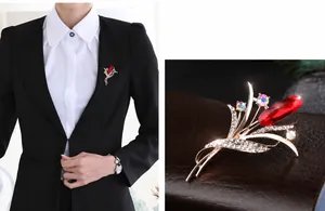 Detail view of flower bouquet brooch with red gemstone and rhinestones on black blazer