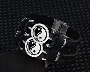 Detail shot of stainless steel buckle engraving on vintage Yin Yang leather bracelet