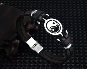 Macro shot of retro leather bracelet with yin yang symbol and stainless steel clasp