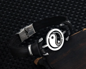 Close-up of the stainless steel buckle with Yin Yang charm on black leather bracelet