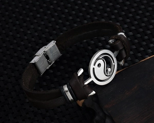 Detailed macro view of retro leather bracelet with stainless steel Yin Yang charm