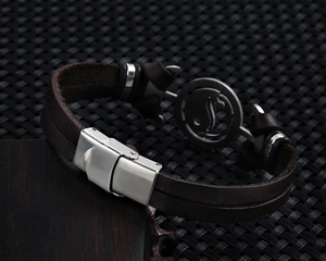 Macro detail of retro yin yang stainless steel clasp and brown leather texture