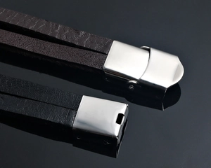 Macro shot of black and brown leather bracelets with polished stainless steel clasp