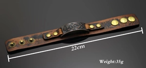 Detailed view of vintage brown leather bracelet with metal studs and button closure
