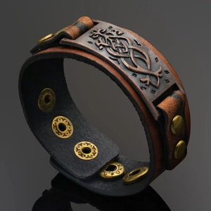 Macro view of wide brown leather bracelet with Celtic knot metal plate and snap button
