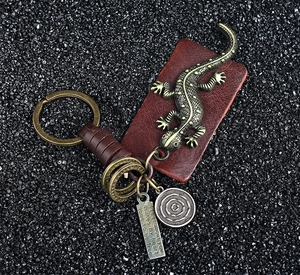 Detail of vintage bronze lizard keychain with brown leather and engraved metal tag
