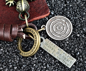 Macro shot of vintage leather keychain featuring bronze lizard and engraved metal tags