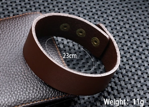 Detail van een bruine leren armband met metalen drukknopen, 23 cm lengte en 11 g gewicht
