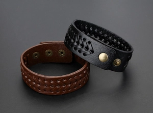 Detail von Vintage-Lederarmbändern mit verstellbaren Druckknöpfen aus Messing