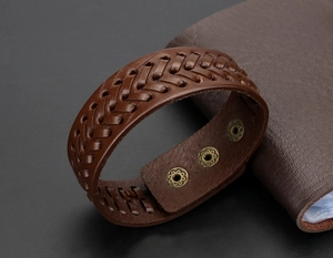 Detailansicht eines braunen breiten Lederarmbands mit drei Metall-Druckknopfverschlüssen
