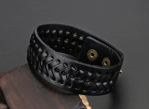 Detail des schwarzen Lederarmbands mit gravierten Vintage-Metall-Druckknöpfen