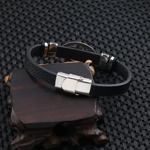 Close-up of black leather men's scorpion bracelet with stainless steel clasp on wood