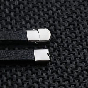 Detailed close-up of textured black leather strap with brushed silver metal clasps