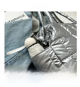 Detail of silver metallic quilted handbag side pocket showing storage for an umbrella