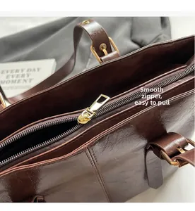 Detalle de la cremallera dorada y hebilla ajustable en el bolso marrón oscuro