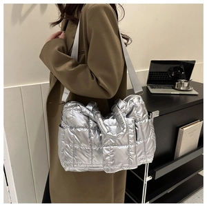 Silver quilted tote bag with metallic finish shown in a stylish office commute setting