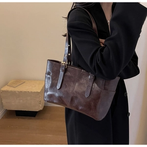 Detalle de bolso tote de cuero vintage marrón oscuro con correas ajustables en modelo