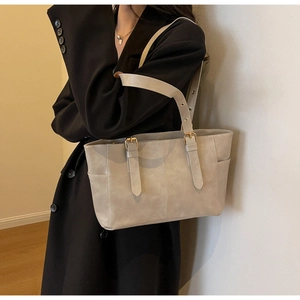 Bolso tote minimalista de cuero mate beige con hebilla de metal y bolsillo lateral