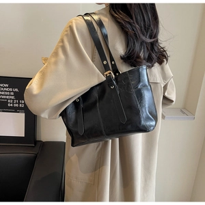 Detalle del bolso de hombro en cuero encerado negro con hebilla metálica ajustable