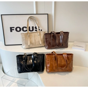 Detalle de cuatro colores clásicos de bolsos tote grandes con hebillas de metal