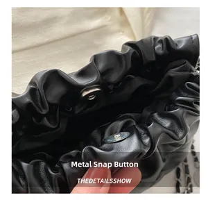 Détail de la fermeture magnétique et de la texture en cuir plissé sur un sac à chaîne