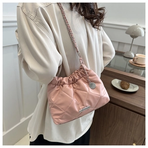 Détail du sac seau matelassé rose avec bandoulière chaîne et plaque métallique