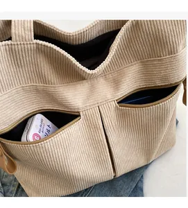 Close-up of corduroy tote bag with dual front zipper pockets for functional storage