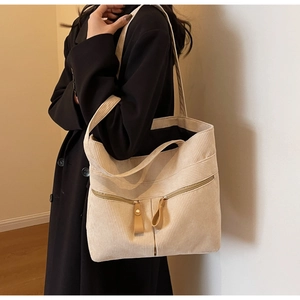 Detail of corduroy tote bag with dual front zipper pockets and textured fabric