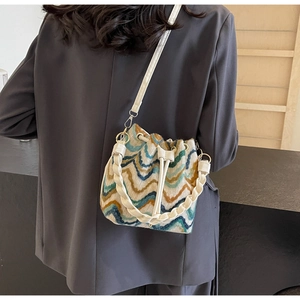 Detalle de bolso saco de punto bohemio con ondas de colores y asa de cuero trenzado a mano