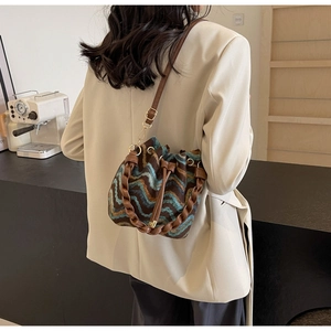 Detalle del bolso bombonera de punto bohemio con motivos de ondas y cordón de cuero