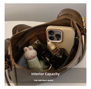 Intérieur spacieux d'un sac à bandoulière marron vintage montrant un grand rangement