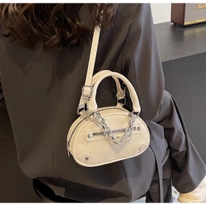 Detail of cream white half-moon crossbody bag with silver chain strap and metal zippers