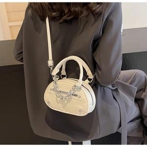 Détail du petit sac bandoulière crème avec chaîne en métal et bandoulière réglable