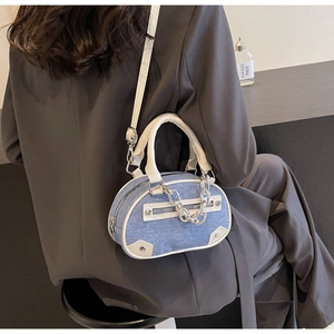 Détail d'un mini sac bandoulière en denim avec finitions argentées et cuir sur un mannequin