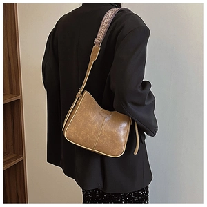 Close-up of retro brown PU leather shoulder bag with ethnic geometric woven strap