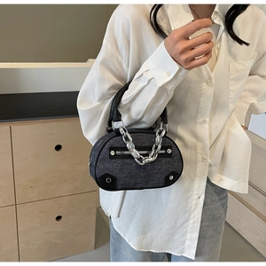 Détail du sac cabas en denim gris foncé avec chaîne argentée et rivets industriels