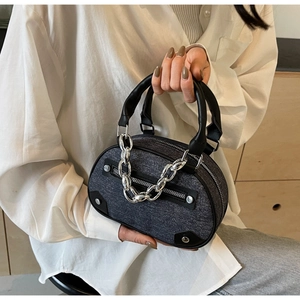 Détail du sac à main gris avec garniture en similicuir noir et grosse chaîne argentée