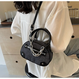 Close-up of grey textured fabric crossbody bag with chunky silver chain and leather handle