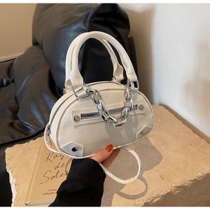 Détail du sac à main en cuir PU blanc avec chaîne en métal argenté et fermeture éclair