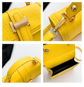 Detail view of yellow croc-effect handbag featuring gold hardware and magnetic closure