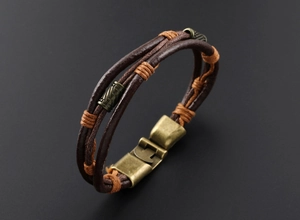 Vue détaillée du bracelet multicouche en cuir tressé avec perles en bronze et fermoir rétro