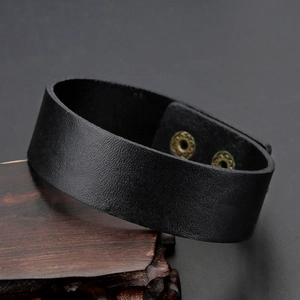 Minimalistische brede zwarte matte leren polsband met dubbele bronzen drukknopen