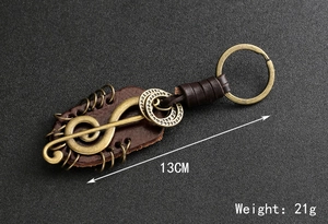 Detail view of vintage bronze clef keychain with leather strap, 13cm length and 21g weight