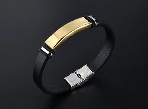 Détail du bracelet en cuir noir avec plaque dorée polie et fermoir déployant en acier inoxydable