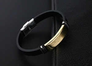 Détail macro du bracelet en cuir pour homme montrant la plaque dorée et le fermoir argenté