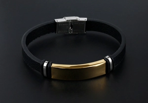 Détail du bracelet en cuir noir avec plaque dorée et fermoir en acier inoxydable