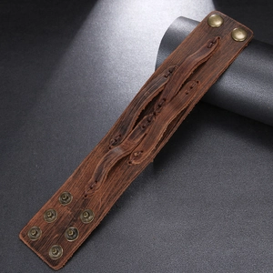 Close-up of vintage brown leather wide bracelet with knotted design and adjustable snaps