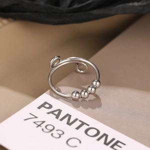 Macro detail of silver rotating beads and spiral design on an anti-anxiety fidget ring