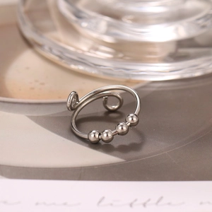Detail view of anti-anxiety ring with four rotating silver beads and open band design