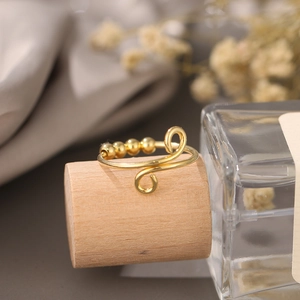 Detailed shot of golden spinning beads on an adjustable stress relief ring for women